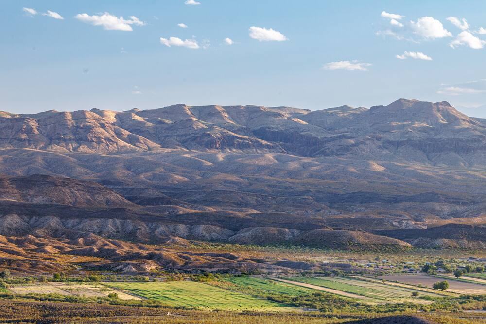 Farm fields in the La Junta de los Rios floodplain below mountains