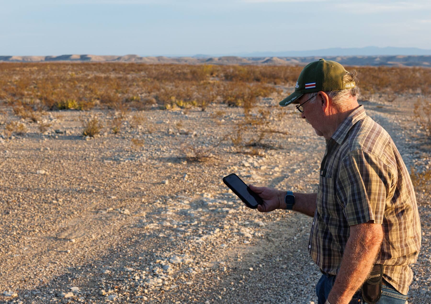 Glenn Merkford checks a map of the planned wall route on his phone